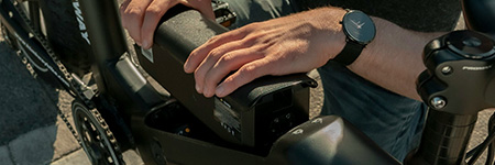 Image of a large lithium batter being placed into an electric bycicle